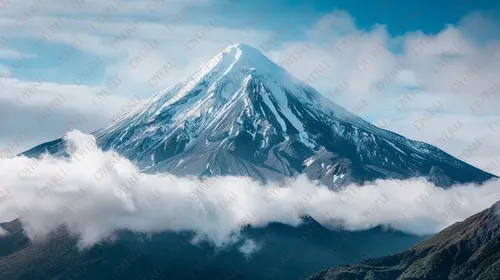 جبل مغطى بالثلوج مع سحب بيضاء في السماء الزرقاء